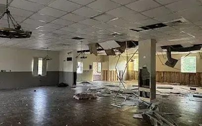 Ceiling tiles fallen across the floor of a commercial room after a leak